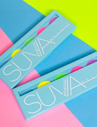 SUVA Beauty's product, UV Taffies in a colorful pink, blue and neon yellow background