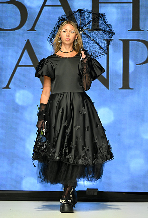 A Caucasian female model wearing black dress designed by Bahar Kianpour at Vancouver Fashion Week 2024