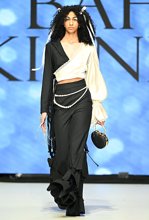 A Caucasian female model wearing black and white garments designed by Bahar Kianpour at Vancouver Fashion Week 2024